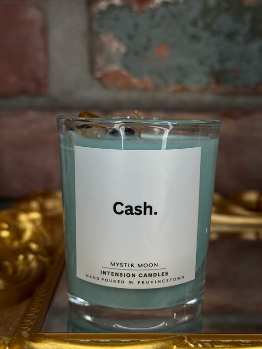 intention Candle labeled 'Cash' by Mystik Moon. with crystals on top