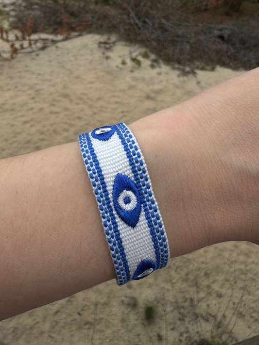 Evil eye blue and white embroidered bracelet on hand