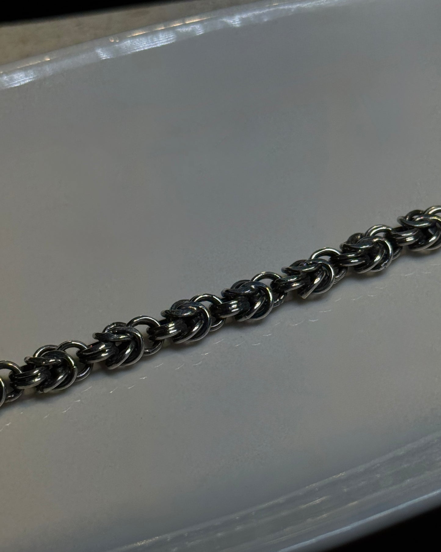Metallic chain on a reflective surface